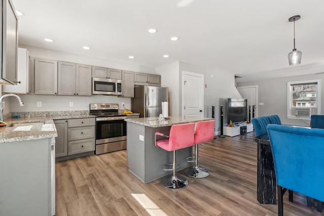 kitchen with appliances with stainless steel finishes, a center island, a breakfast bar area, and recessed lighting