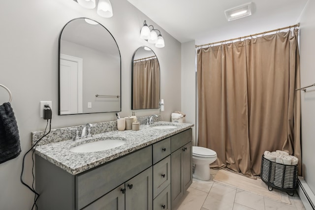 full bathroom with double vanity, toilet, a sink, and a baseboard radiator