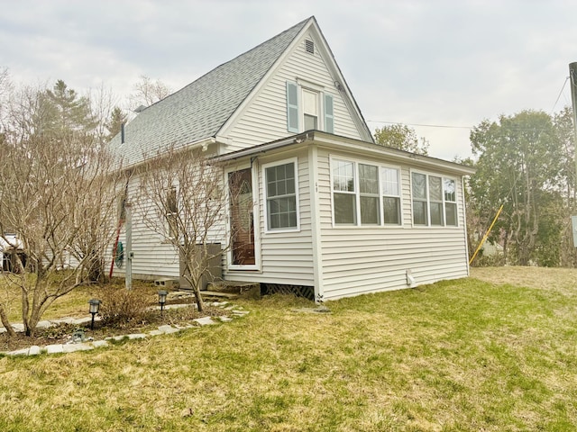 exterior space featuring roof with shingles and a yard