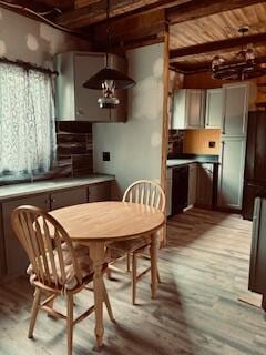 dining area featuring beam ceiling, wooden ceiling, and light wood-style flooring