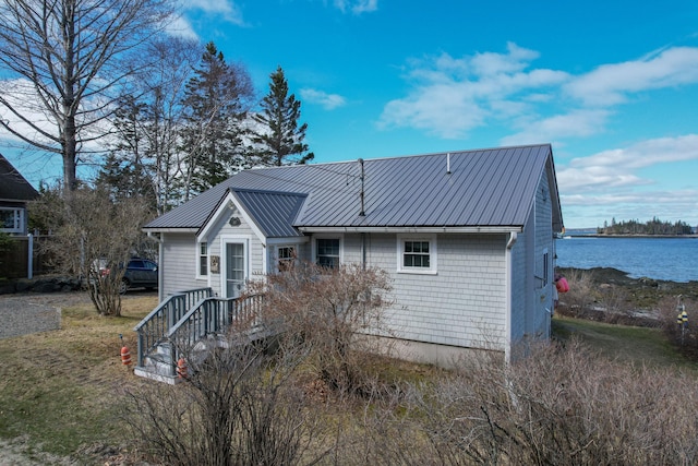 view of front of house with metal roof and a water view