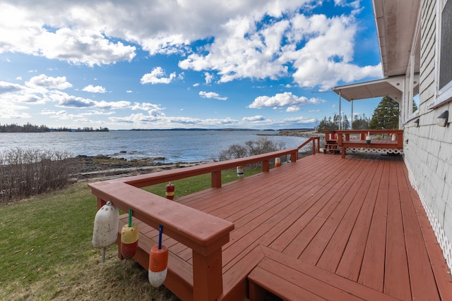 wooden terrace with a yard and a water view