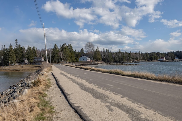 view of road featuring a water view and a wooded view