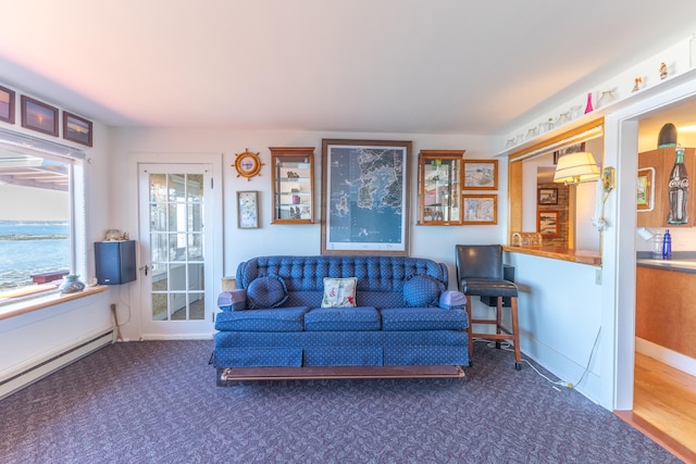 carpeted living room featuring a baseboard heating unit
