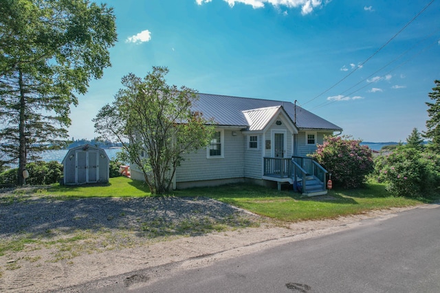 397 Cape Split Rd, Addison, ME 04606 - view of front of house featuring a shed, a front yard, and a metal roof