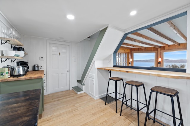 kitchen featuring open shelves, a breakfast bar, light wood-type flooring, recessed lighting, and wood counters