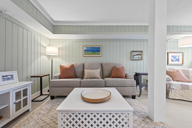 living area featuring wooden walls and light carpet