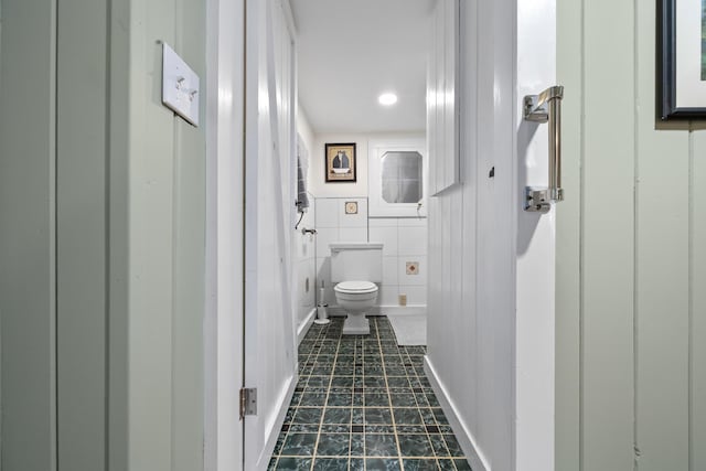 bathroom with tile walls and toilet