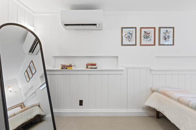 carpeted bedroom with crown molding, wainscoting, and a wall unit AC