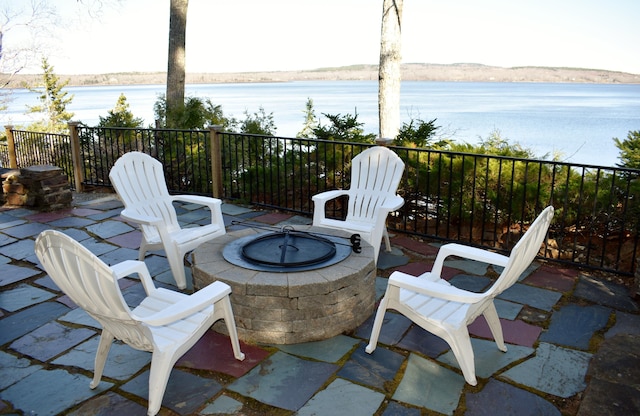 view of patio with a water view and a fire pit