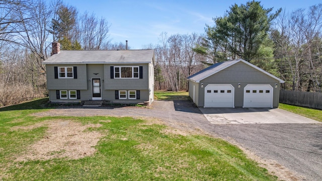 135 Williams Rd, Newport, ME 04953 - split foyer home featuring an outdoor structure, a chimney, fence, a front lawn, and a garage