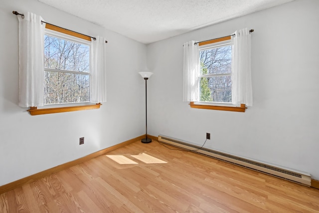 135 Williams Rd, Newport, ME 04953 - spare room featuring baseboard heating, baseboards, wood finished floors, and a textured ceiling