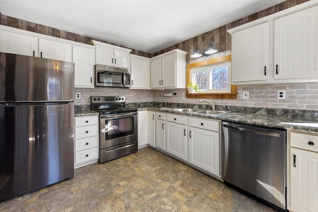 135 Williams Rd, Newport, ME 04953 - kitchen with a sink, backsplash, stone finish floor, white cabinetry, and appliances with stainless steel finishes