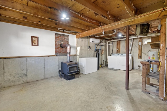 135 Williams Rd, Newport, ME 04953 - unfinished below grade area featuring refrigerator, washer and dryer, a wall mounted air conditioner, gas water heater, and a wood stove