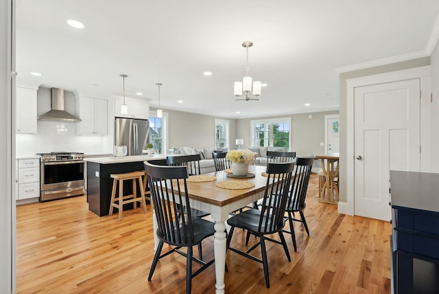 dining area featuring crown molding, recessed lighting, an inviting chandelier, and light wood-style flooring