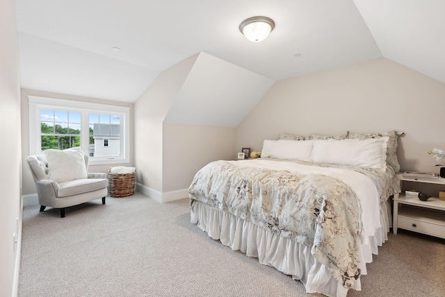 carpeted bedroom featuring baseboards and lofted ceiling