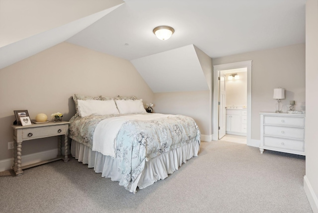 bedroom featuring ensuite bath, vaulted ceiling, carpet, and baseboards