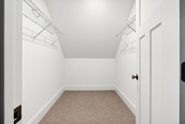 spacious closet with carpet flooring and vaulted ceiling