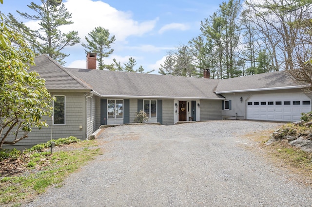 single story home with driveway, roof with shingles, an attached garage, and a chimney