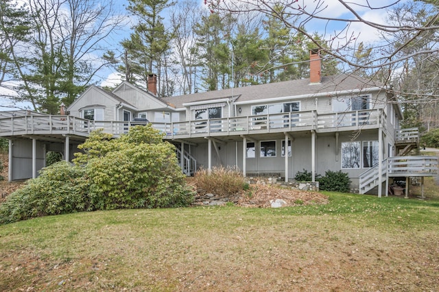 back of house featuring stairs, a yard, and a wooden deck