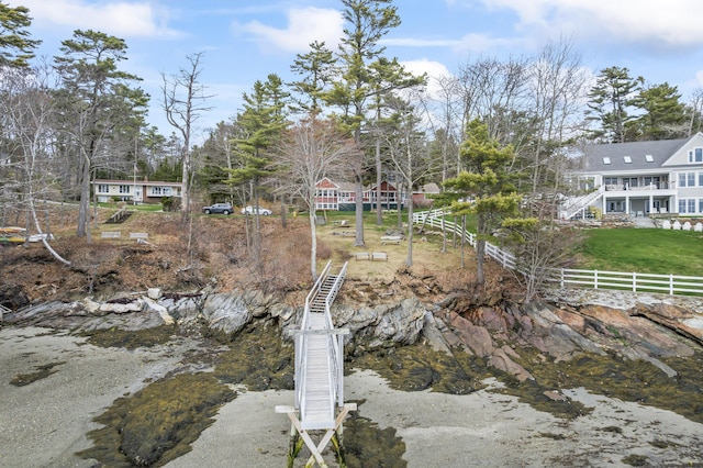 exterior space featuring stairway, fence, and a water view