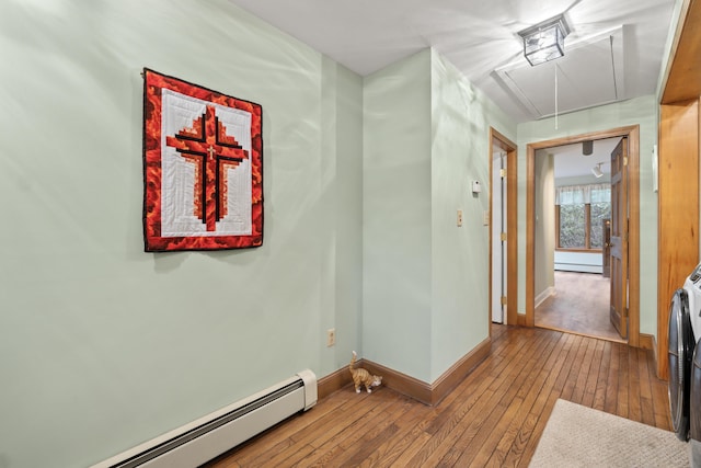 hallway with attic access, baseboards, hardwood / wood-style flooring, and a baseboard radiator