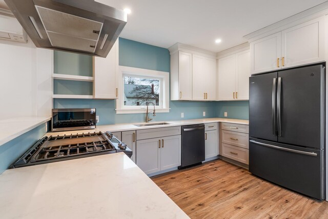 32 Webster Ave, Bangor, ME 04401 - kitchen with light wood-style flooring, freestanding refrigerator, light countertops, a sink, and dishwashing machine
