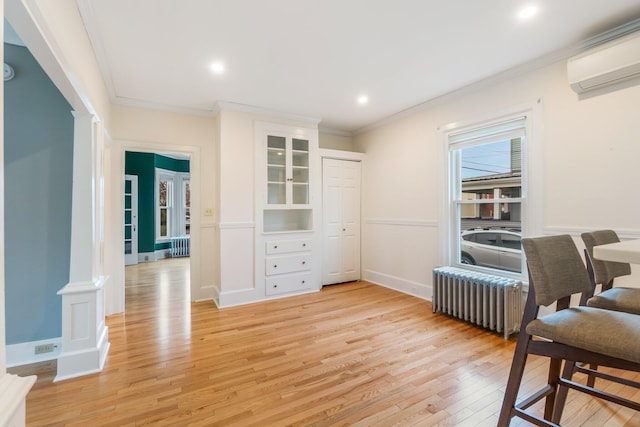 32 Webster Ave, Bangor, ME 04401 - sitting room featuring radiator, a wall mounted AC, light wood-style floors, crown molding, and baseboards