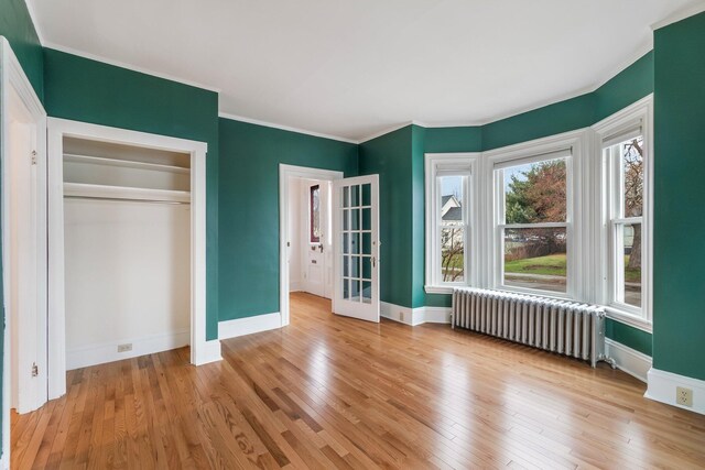 32 Webster Ave, Bangor, ME 04401 - unfurnished bedroom featuring wood finished floors, baseboards, crown molding, and radiator