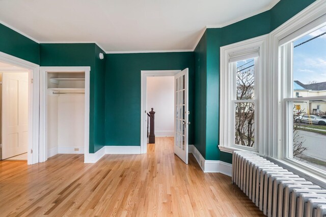 32 Webster Ave, Bangor, ME 04401 - interior space featuring light wood-style flooring, a closet, baseboards, ornamental molding, and radiator heating unit