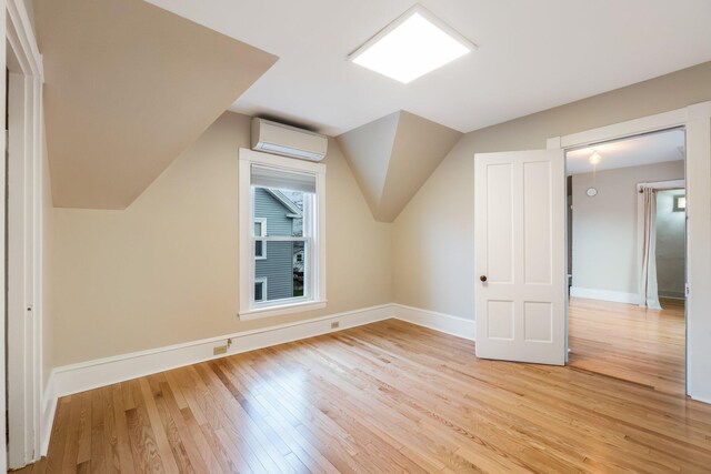 32 Webster Ave, Bangor, ME 04401 - bonus room with baseboards, vaulted ceiling, light wood-style flooring, and an AC wall unit