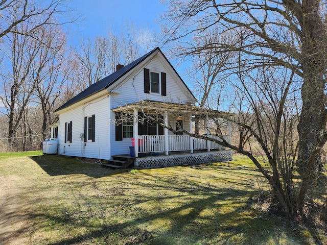 217 Washington Rd, Jefferson, ME 04348 - view of front of home with covered porch, a chimney, and a front yard