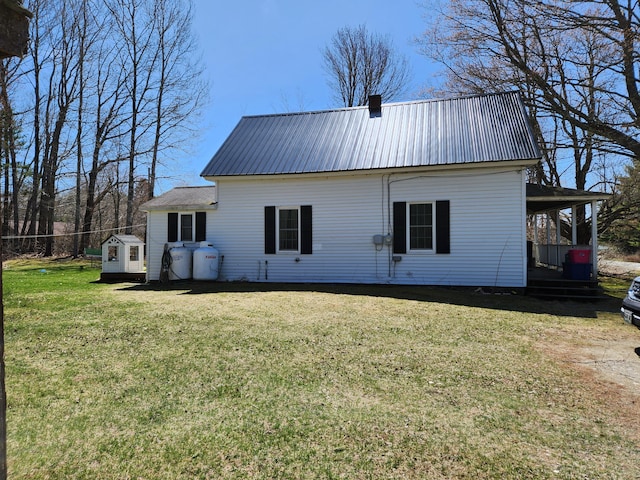 217 Washington Rd, Jefferson, ME 04348 - rear view of property with a storage unit, an outdoor structure, a yard, and metal roof