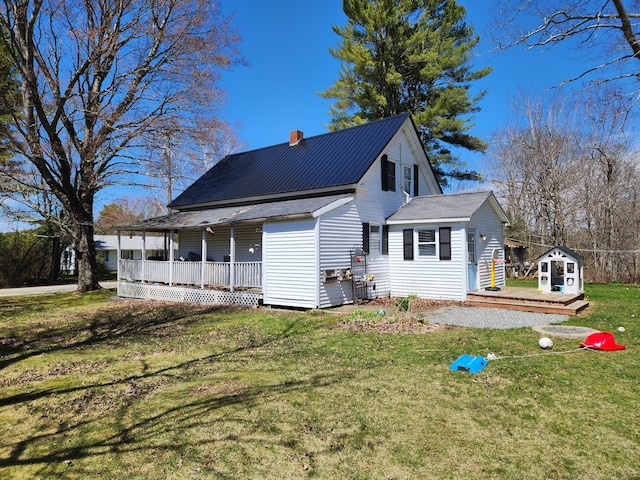 217 Washington Rd, Jefferson, ME 04348 - rear view of property with an outdoor structure, a chimney, a storage unit, a porch, and a yard