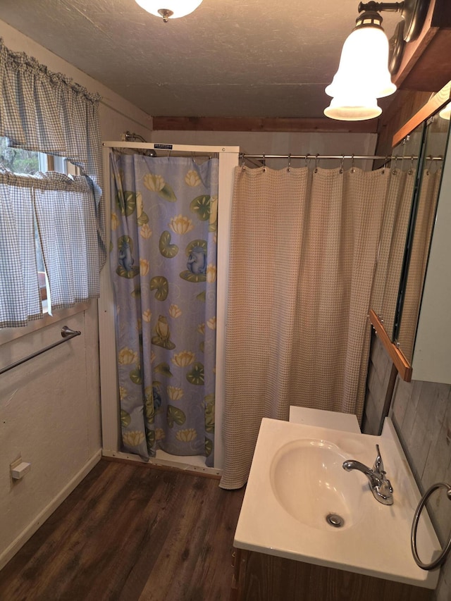 bathroom featuring vanity, baseboards, wood finished floors, and a shower with shower curtain
