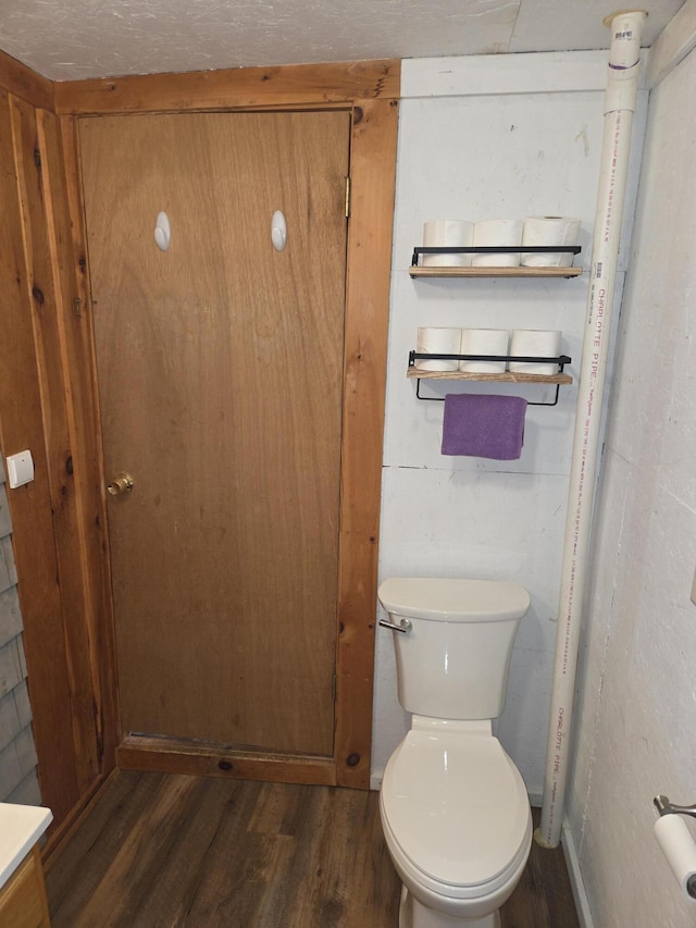 bathroom featuring wood finished floors and toilet