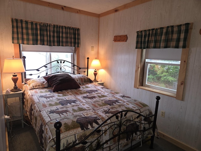 carpeted bedroom featuring wood walls