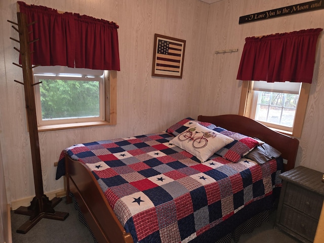 bedroom with wooden walls and carpet flooring