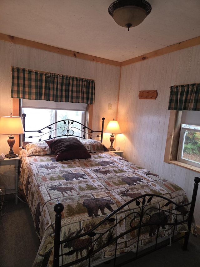 carpeted bedroom with wood walls