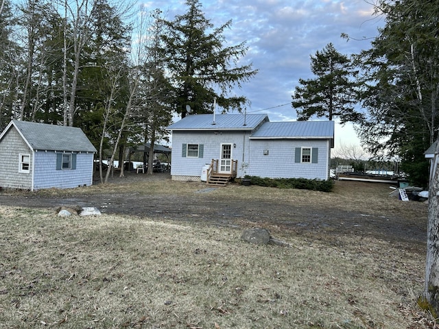 rear view of house featuring an outdoor structure and metal roof