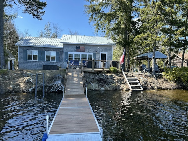 view of dock with a gazebo and a deck with water view