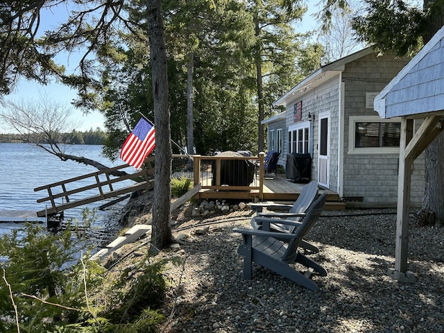 view of yard with a deck with water view