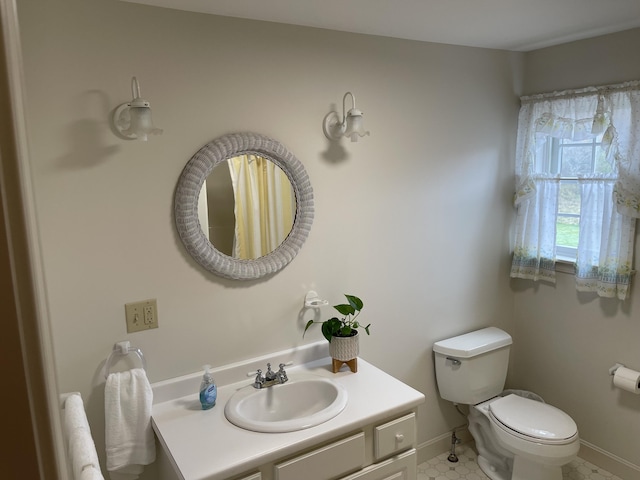 bathroom with toilet, tile patterned floors, vanity, and baseboards