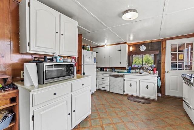 kitchen with light floors, stainless steel microwave, freestanding refrigerator, light countertops, and dishwashing machine