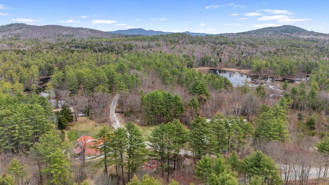aerial view with a wooded view and a water and mountain view