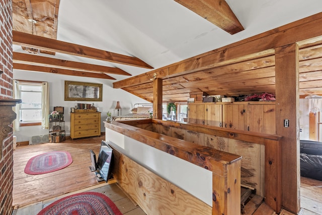 interior space with visible vents, hardwood / wood-style flooring, and vaulted ceiling with beams
