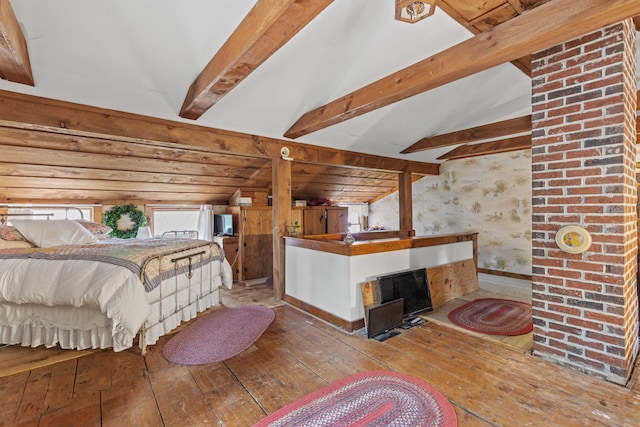 bedroom featuring vaulted ceiling with beams, a fireplace, and wood-type flooring
