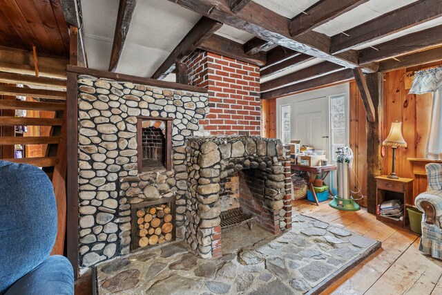 living room featuring hardwood / wood-style floors, beam ceiling, and a fireplace