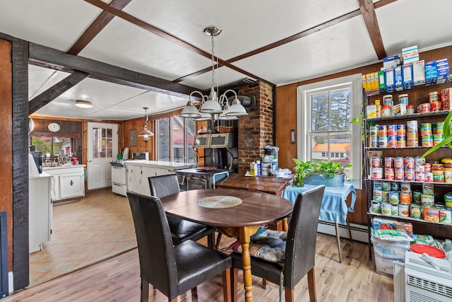 dining space with wood finished floors, wood walls, a chandelier, and a baseboard radiator