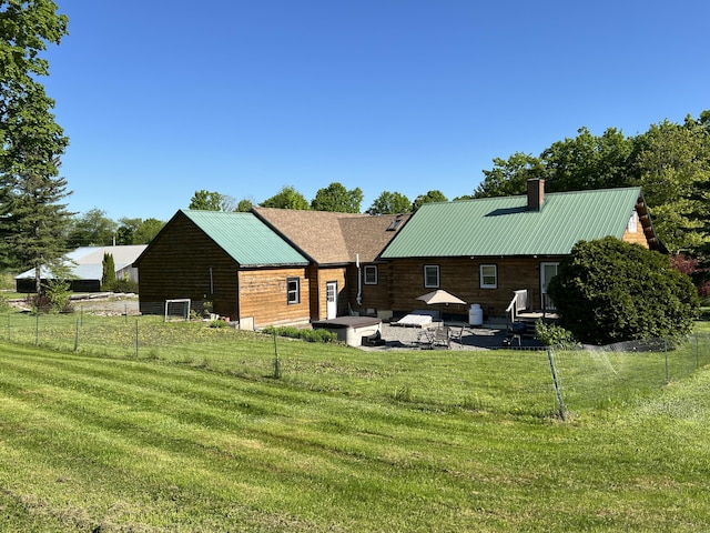 129 Ledge Hill Rd, Corinth, ME 04427 - rear view of house with a patio area, a chimney, and metal roof